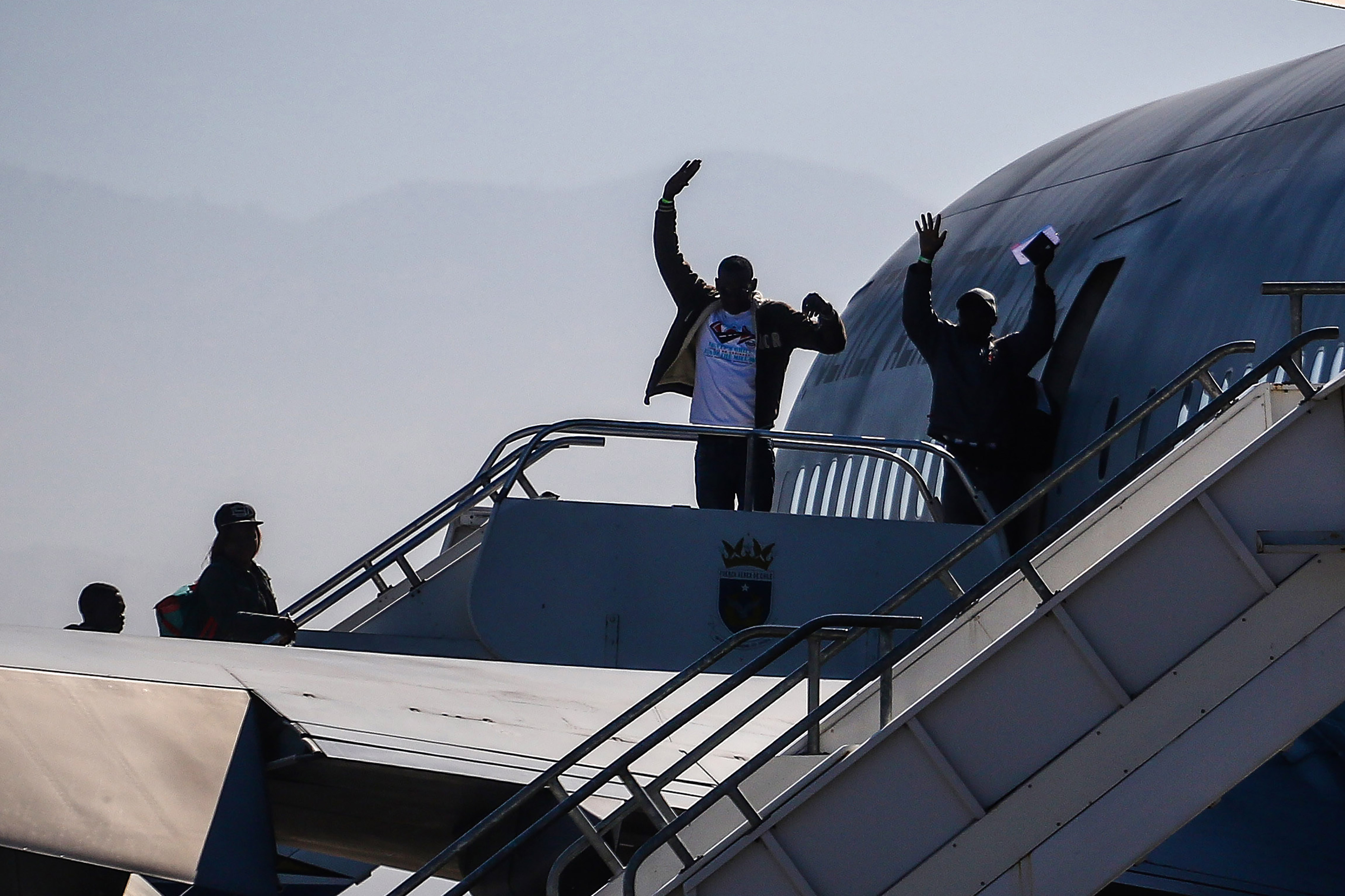 07 de Noviembre de 2018 / SANTIAGO Ciudadanos haitianos levantan sus brazos despidiéndose mientras abordan el avión de la Fach en el grupo 10 para regresar a su páis, en el marco del denominado "Plan Humanitario de Regreso Ordenado", para las personas que llevan meses o años en Chile y que por dificultades económicas no les fue posible estabilizarse en el país. FOTO: HANS SCOTT / AGENCIAUNO