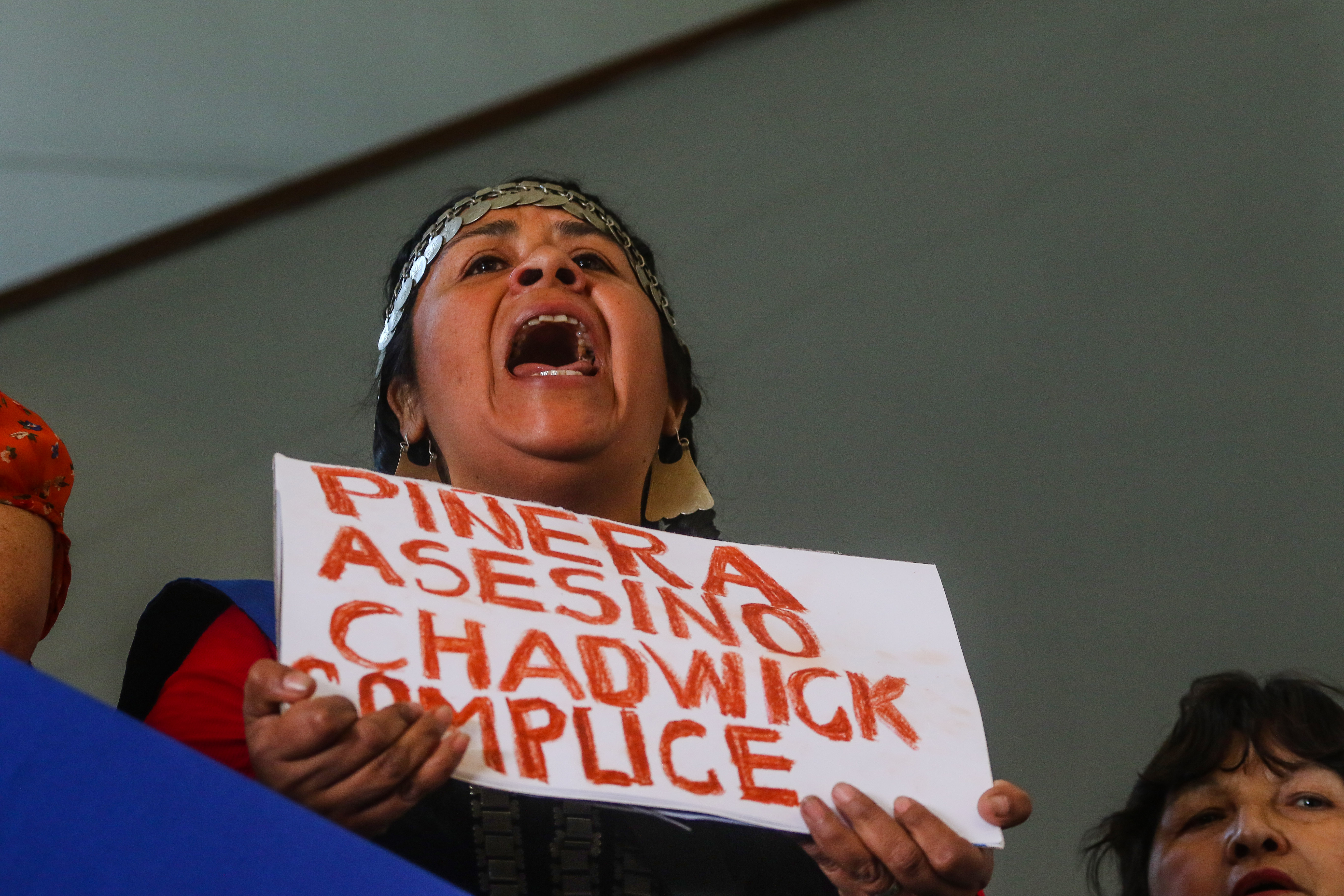 15 de Noviembre de 2018 / SANTIAGO Una mapuche se manifiesta con un cartel con la leyenda "Piñera Asesino Chadwick Complice", al interior de la casa central de la Universidad de Chile, durante una conferencia de prensa de diversas organizaciones sociales, repudiando el asesinato del comunero Camilo Catrillanca. FOTO: HANS SCOTT / AGENCIAUNO
