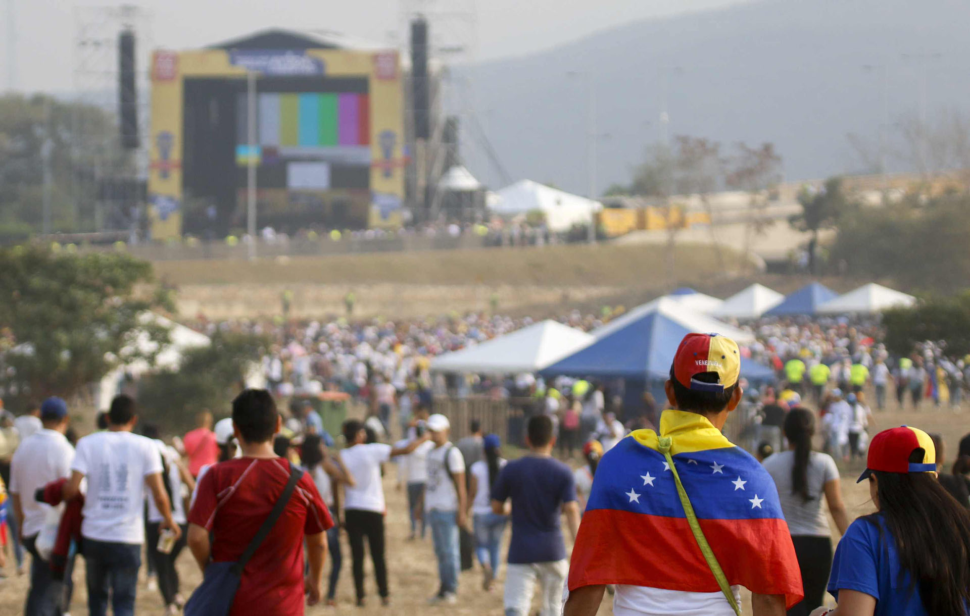 People wait for the start of "Venezuela Aid Live" concert, organized by British billionaire Richard Branson to raise money for the Venezuelan relief effort at Tienditas International Bridge in Cucuta, Colombia, on February 22, 2019 - The concert was organized by British billionaire Richard Branson to raise money for the Venezuelan relief effort. Venezuela's political tug-of-war morphs into a battle of the bands on Friday, with dueling government and opposition pop concerts ahead of a weekend showdown over the entry of badly needed food and medical aid. (Photo by SCHNEYDER MENDOZA / AFP)