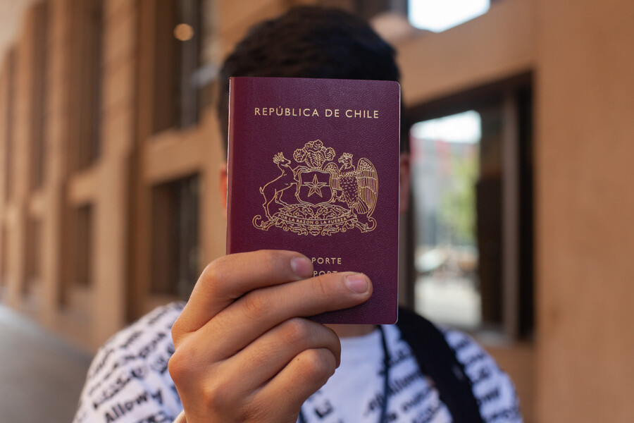 Personas muestran su pasaporte en el marco del anuncio a la rebaja de precio de este documento, Foto: Lukas Solís/AGENCIA UNO